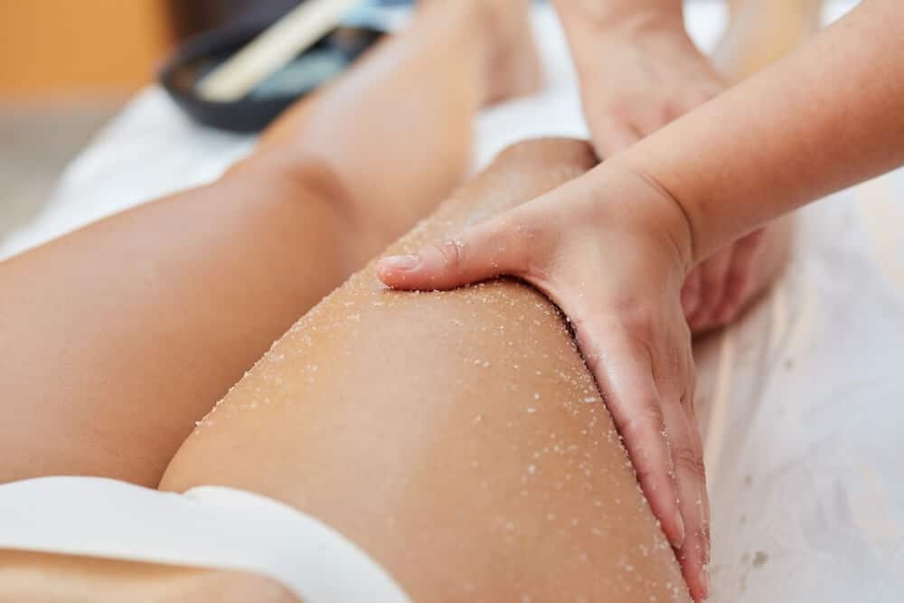 photo of a leg receiving a body scrub exfoliation